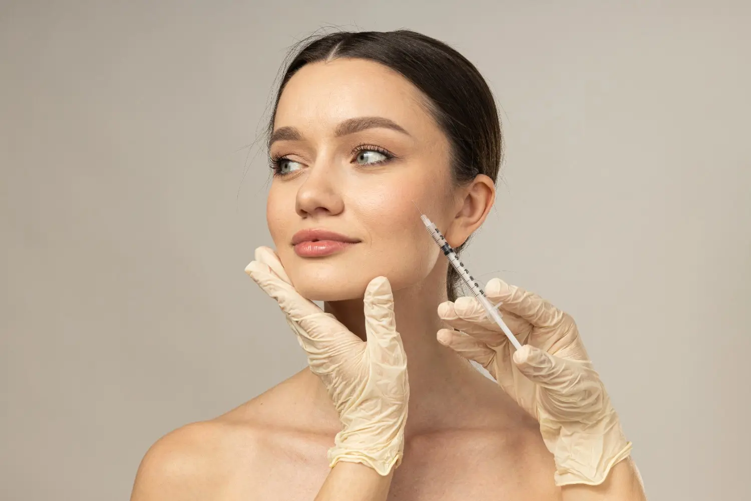 Woman receiving a Botox injection in the cheek area during an aesthetic treatment